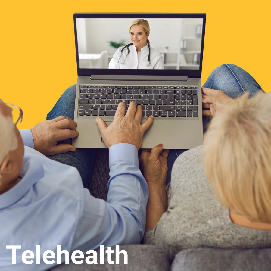 Independa Telehealth feature — senior couple on sofa in a video call with a doctor on their laptop