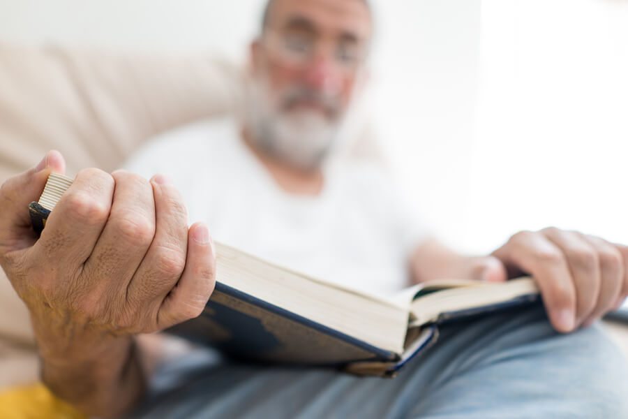 Elderly man sitting and reading a book