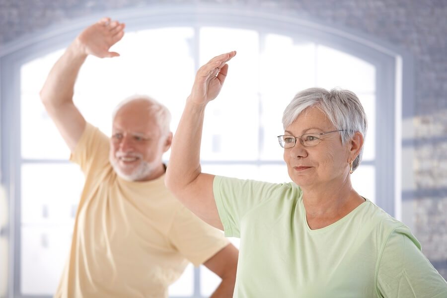 Old couple doing exercises in the gym.